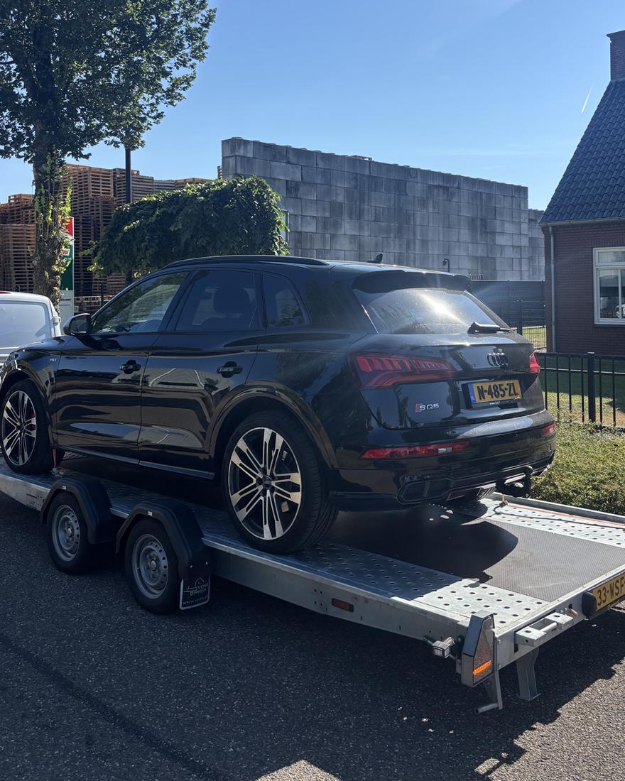 Zwarte Audi SQ5 vastgezet op de aanhanger, klaar voor vertrek